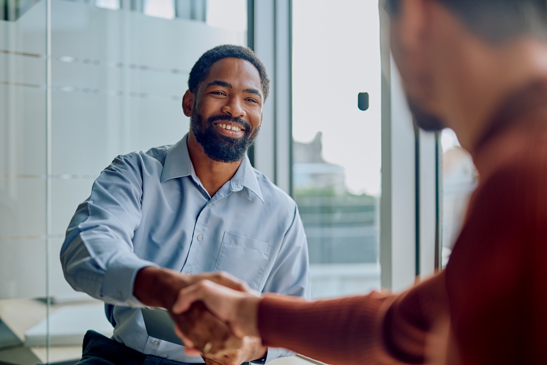 Two business professionals shaking hands, representing a trust-based professional services relationship covered by professional indemnity insurance in South Africa